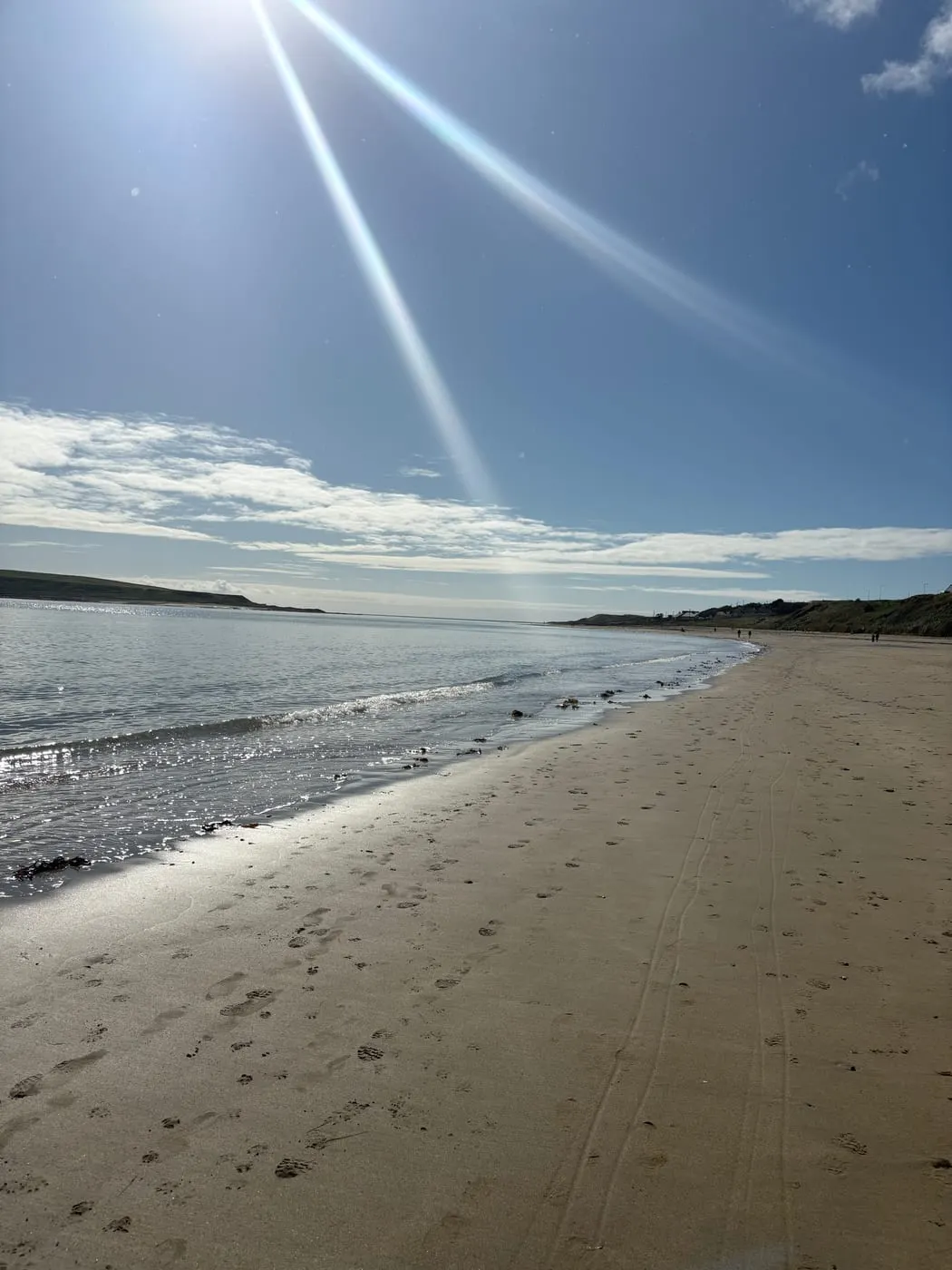 Sunlight breaking over the water on a coastal walk