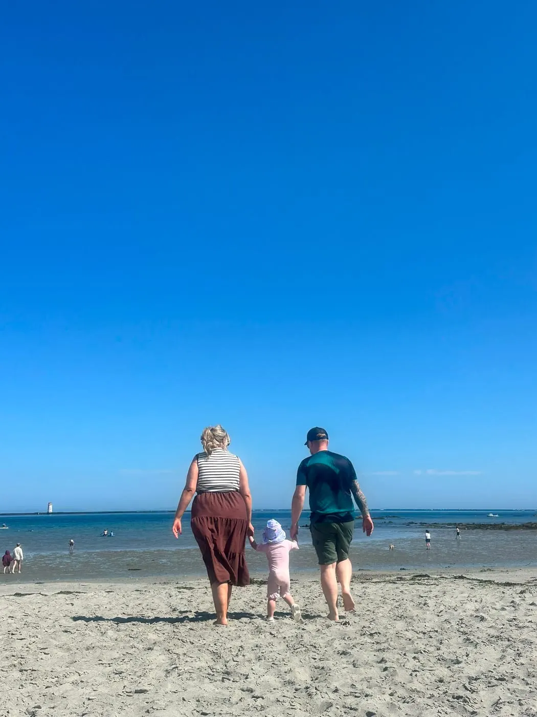 Family beach walk on a bright summer day in County Down