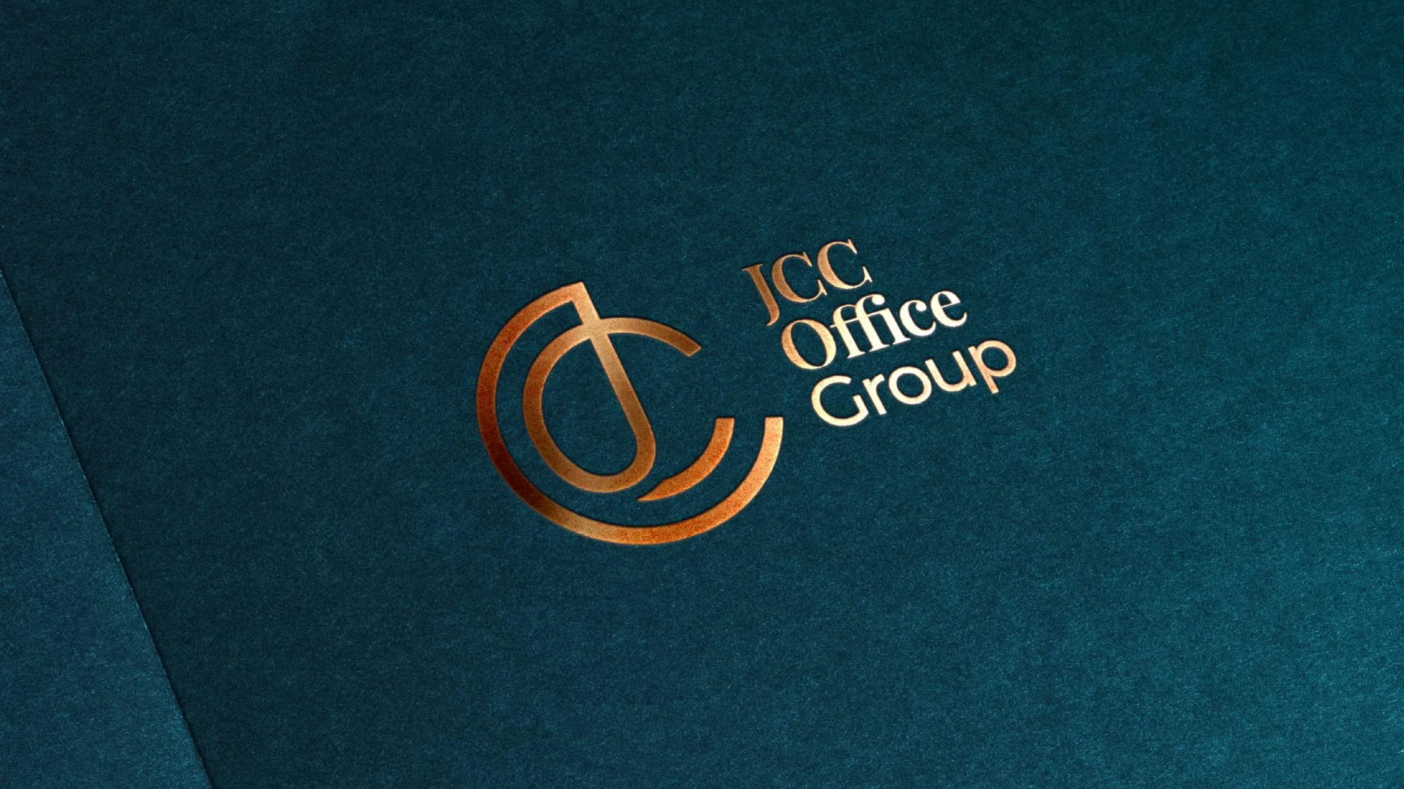 JCC Office Group logo foiled on a dark navy surface